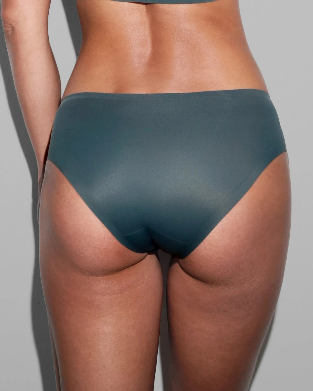 Back view of slate blue seamless bikini briefs showing the smooth moderate-coverage fit and invisible edges.