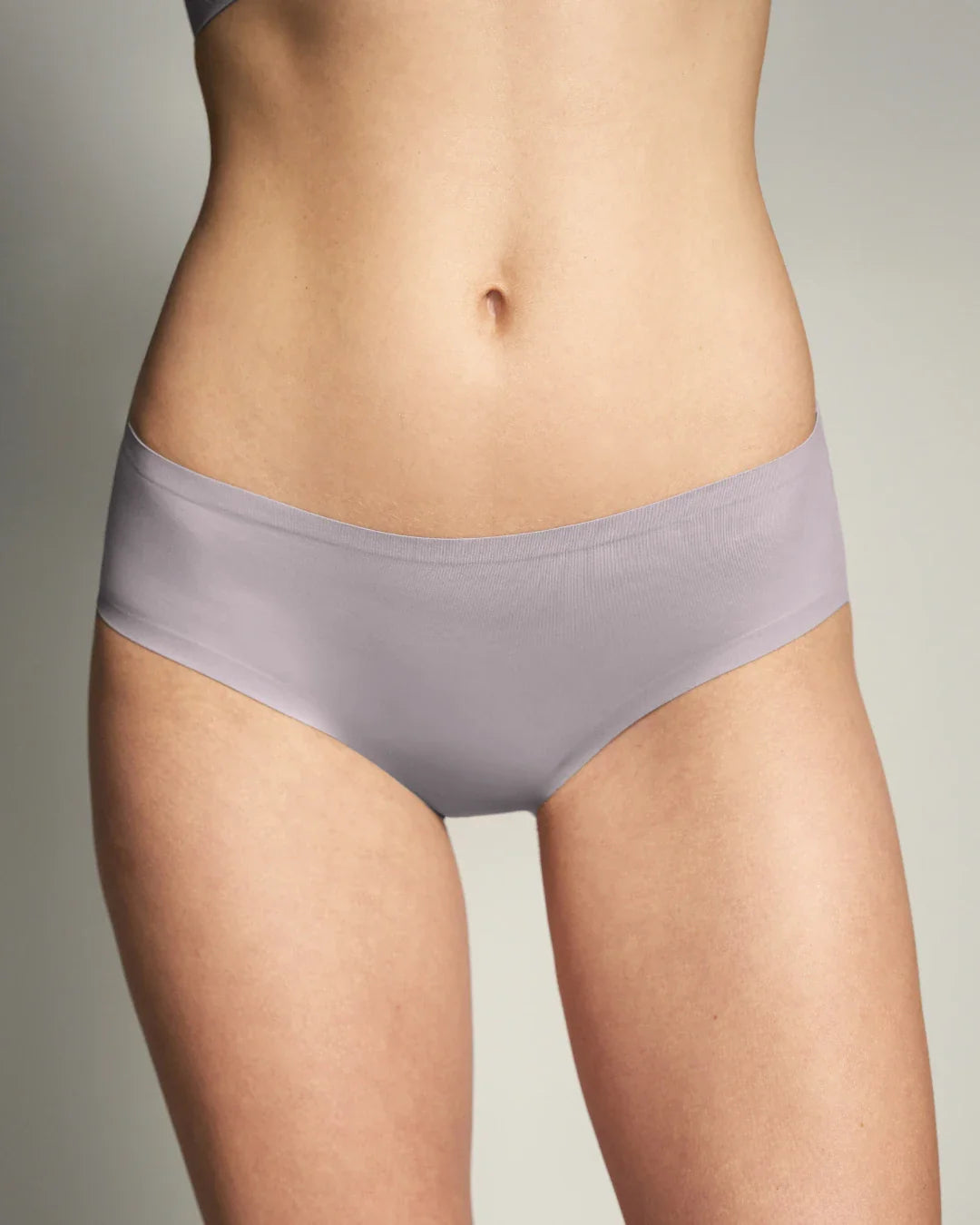 Back view of model wearing haze lavender wireless bralette and bikini panties set.