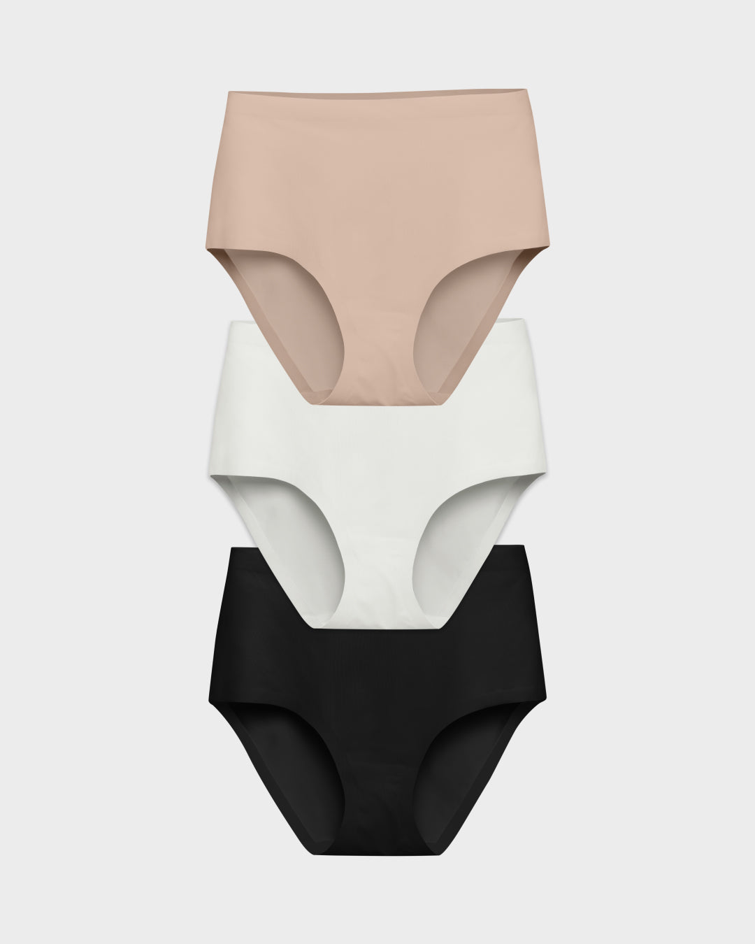 Three seamless high-waisted panties in nude, pearl, and black stacked in a flat lay.