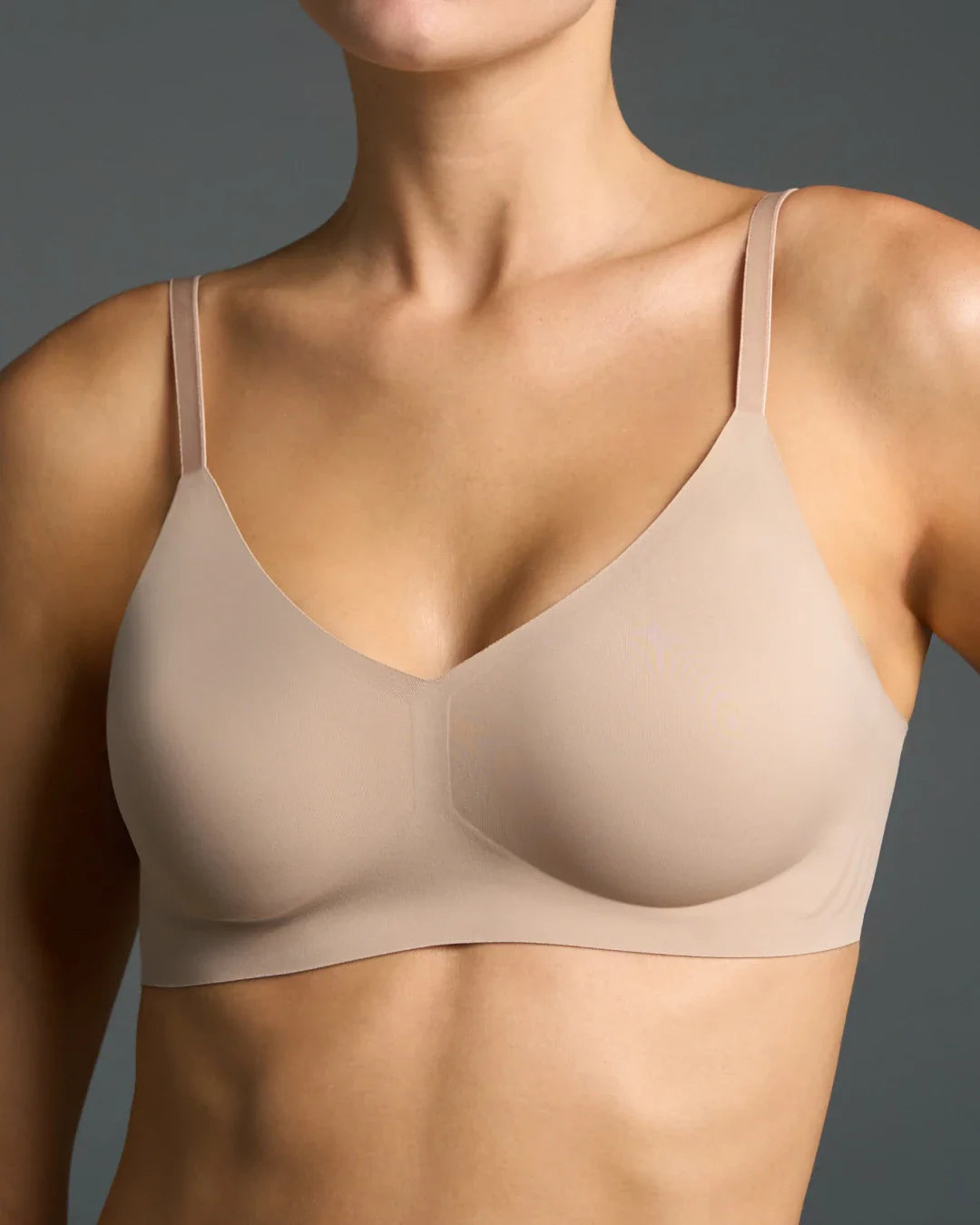 Wire-free T-shirt bra in nude with a V-neckline, thin adjustable straps, and smooth seamless cups.