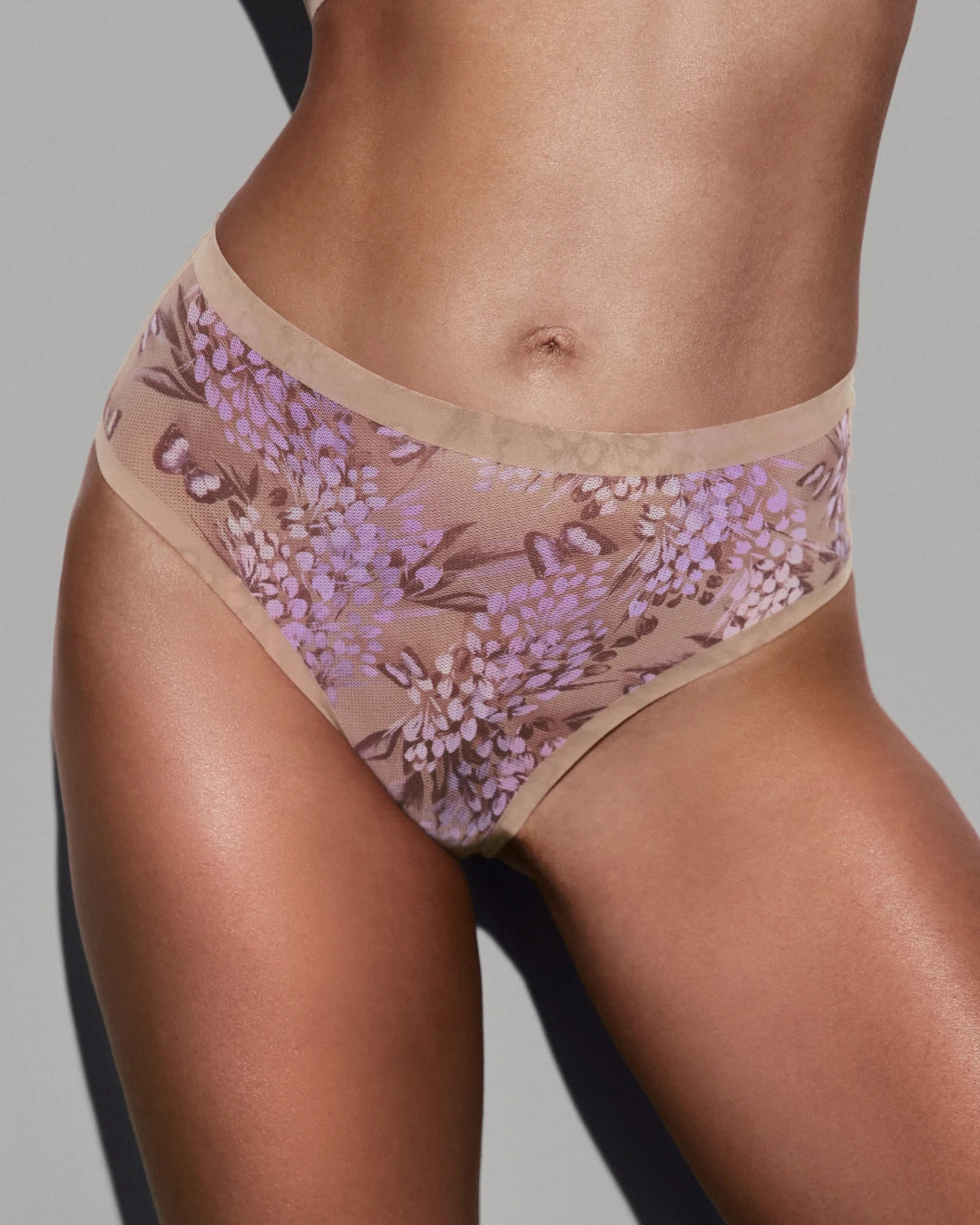 Side view of model wearing parisian floral-print sheer high-cut panties with mesh detail.